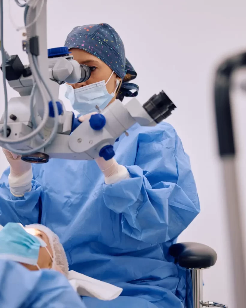 Medical eye expert looking through microscope during surgery at ophthalmology clinic. Copy space.